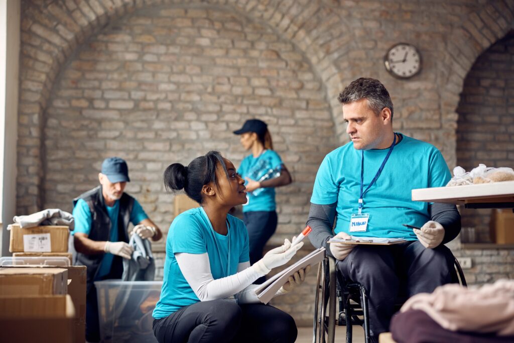 Lady volunteer talking to another volunteer on wheelchair